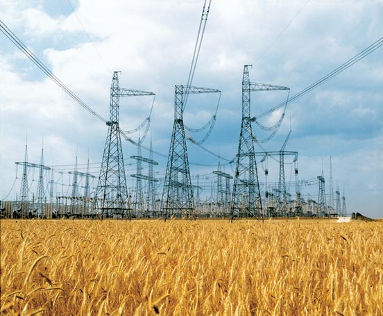 High-voltage electrical transmission lines and pylons against the sky.